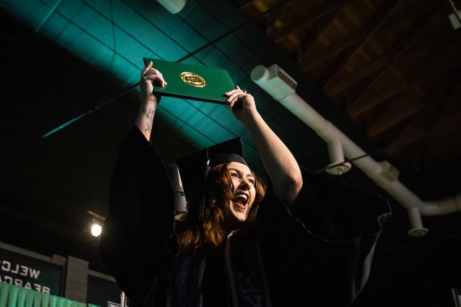 周六，<a href='http://threatassessment.shootapp.net'>和记棋牌娱乐</a>的一名毕业生在毕业典礼上展示她的毕业证书.